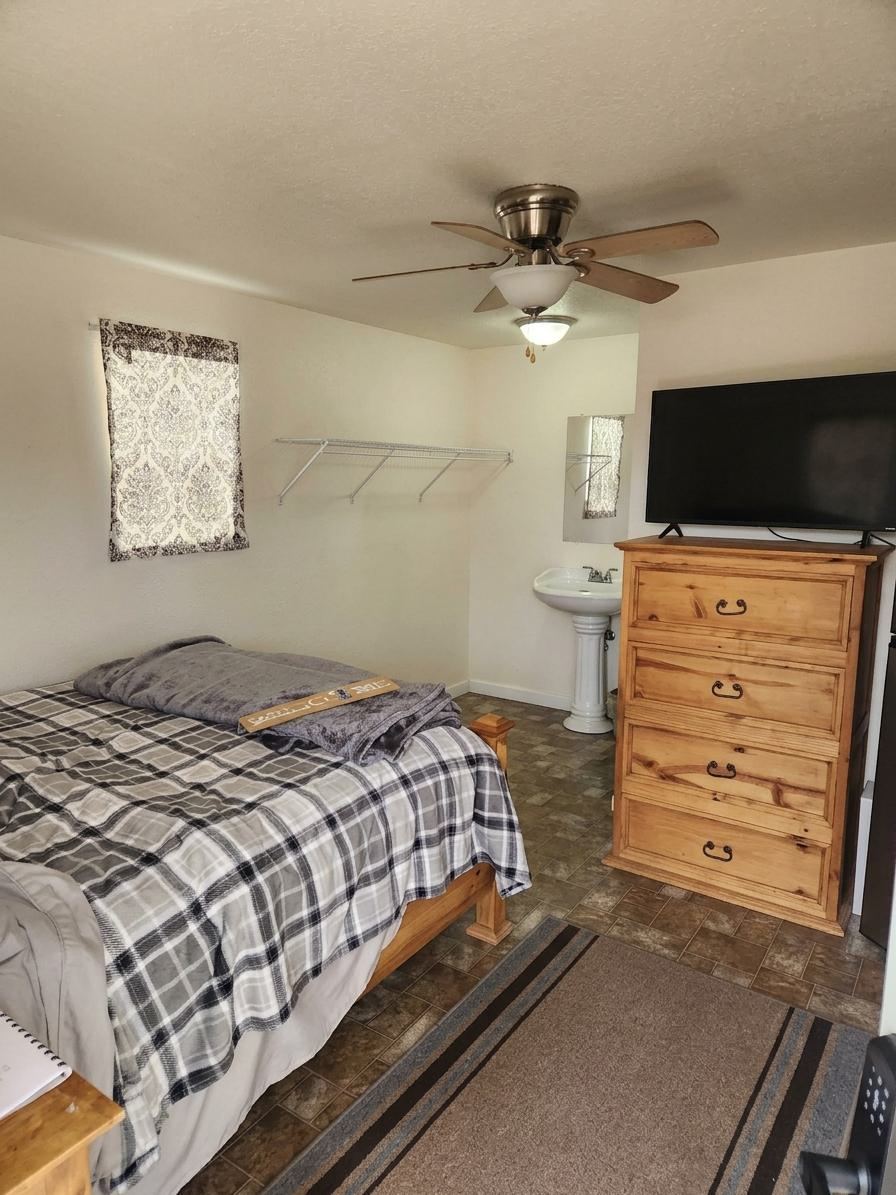 Inside a cabin — bed, dresser and TV